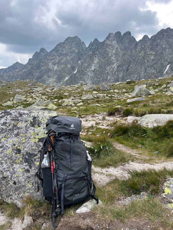 services-05 A hiking backpack resting on rocky terrain with Tatra Mountains in the background.